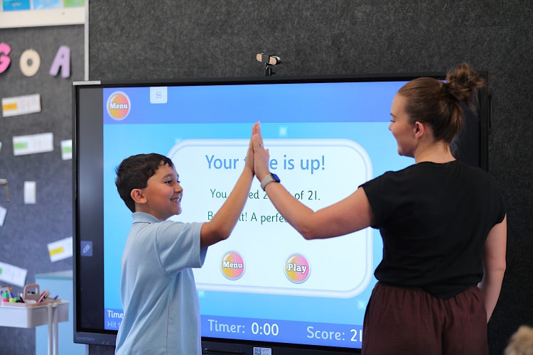Photo of a teacher and student high fiving