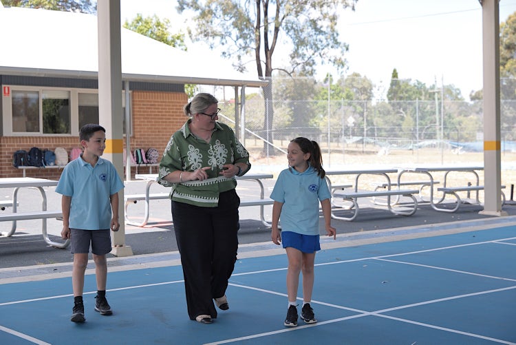 Photo of the Principal walking with 2 students