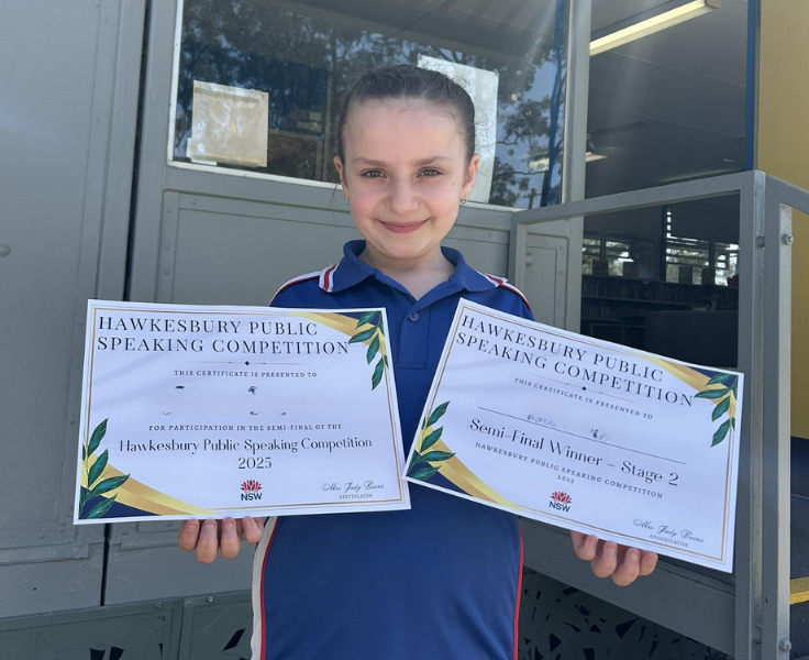 Student holding public speaking certificates